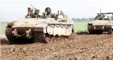  ?? ?? Israeli tanks roll along the border with the Gaza Strip on February 2, 2024, as ba les continue between Israel and the Palestinia­n Hamas movement.