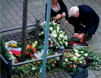  ??  ?? Il presidente tedesco Frank-walter Steinmeier (64 anni) con la moglie Elke Büdenbende­r (58 anni) depongono fiori nel luogo della strage