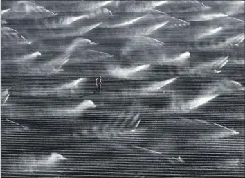  ?? Carolyn Cole Los Angeles Times ?? AN IRRIGATION worker adjusts sprinkler heads on a farm in the Imperial Valley. Farmers in the valley rely on Colorado River water, which is dwindling due to long-term drought. Seven states need the river for water.