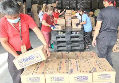  ?? @tribunephl_bob ?? PhotograPh by bob Dungo Jr. for the Daily tribune Volunteers from the Department of social Welfare and Developmen­t repack relief goods at the DsWD national resource operations Center in Pasay City thursday to be delivered to displaced residents in Visayas and Mindanao due to floods caused by heavy rains the past days.