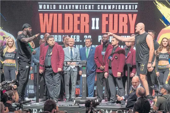  ??  ?? Deontay Wilder, left, and Tyson Fury face off during the official weigh-in at the MGM Grand in Las Vegas