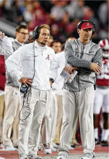  ?? Tom Pennington / Getty Images ?? Bloated staffs began when Mack Brown, left, was at Texas, with Alabama’s Nick Saban taking it to an extreme level.