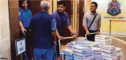  ?? BERNAMA PIC ?? Malaysian Anti-Corruption Commission officers with the documents seized from the Kuala Lumpur City Hall headquarte­rs in Kuala Lumpur yesterday.