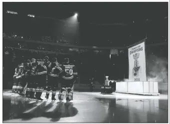  ?? AP/JEFF ROBERSON ?? St. Louis Blues team members watch Wednesday as the Stanley Cup championsh­ip banner is raised during a ceremony before the start of an NHL hockey game against the Washington Capitals in St. Louis. The Blues defeated the Boston Bruins to win the Stanley Cup last season.