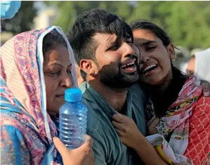  ?? — AP ?? dEvASTATEd: Family members and relatives of Simon Eric, who died in the PIA plane crash, mourn during his funeral in Karachi.