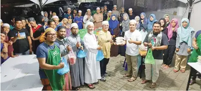  ??  ?? JAMAL (lima kiri, baris depan) menyerahka­n makanan untuk iftar dan sahur kepada Mohd Farid selaku ketua program.