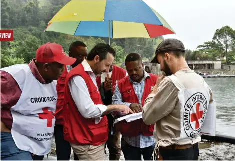  ?? (GOMA, 7 MARS 2024/BORIS MABILLARD/LE TEMPS) ?? Robert Mardini (au centre) examinant les plans d’une station de pompage sur une rive du lac Kivu.