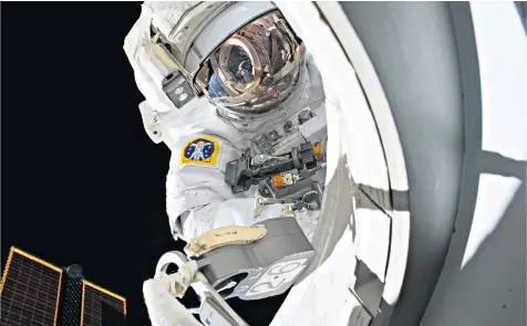  ??  ?? Astronaut Scott Kelly on a spacewalk outside the Internatio­nal Space Station and below right, facing his twin brother Mark. Scientists found their DNA differed upon his return to Earth