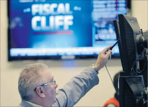  ?? HENNY RAY ABRAMS/ THE ASSOCIATED PRESS ?? A trader works on the floor of the New York Stock Exchange in New York as renewed efforts get underway in Washington to resolve the impending ‘ fiscal cliff.’