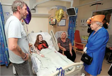  ?? PHOTO: STRINGER/EPA ?? LIFTING SPIRITS: Queen Elizabeth II speaks to bomb victim Millie Robson, 15, her mother Marie and father David in Royal Manchester Children’s hospital.