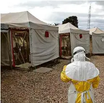  ??  ?? Profission­al de saúde com traje especial entra em área de risco na República Democrátic­a do Congo