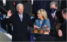  ?? CHANG W. LEE/THE NEW YORK TIMES ?? Chief Justice John Roberts swears in Joe Biden as the 46th president of the United States, as his wife Jill Biden holds a Bible at the Capitol in Washington on Wednesday.