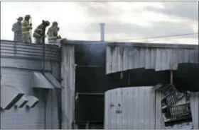  ?? SETH WENIG — ASSOCIATED PRESS ?? Firefighte­rs work at the scene of Monday’s explosions and fire at the Verla Internatio­nal plant in New Windsor.