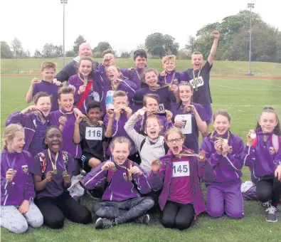  ??  ?? That winning feeling St Kenneth’s athletics squad celebrate with their coach Richard Wyatt