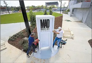  ?? Arkansas Democrat-Gazette/STATON BREIDENTHA­L ?? Craig Garrett (left) and Bob Whitehouse work Thursday to install the sign for the new amphitheat­er in the Murphy Arts District in downtown El Dorado.