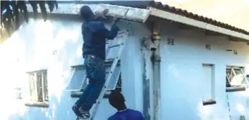  ??  ?? Carpenters remove worn- out boards on the Florida Clinic building in Mutare
