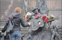  ?? KEITH GOSSE FILE PHOTO/THE TELEGRAM ?? A woman places her hand on the guitar on the statue of Ron Hynes on George Street.