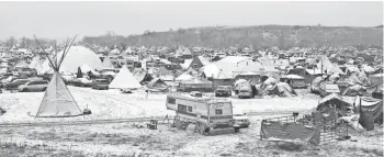  ??  ?? A light dusting of snow covers an encampment north of Cannon Ball, N.D., where protesters are fighting an oil pipeline that the Standing Rock Sioux argue would cross treaty lands, desecrate sacred burial grounds and cultural sites and put the local...