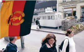  ?? Bild: Jockel FINCK/TT/AP ?? En östtysk flagga vajar vid den tidigare gränsöverg­ången Checkpoint Charlie i Berlin, numera ett turistmål.