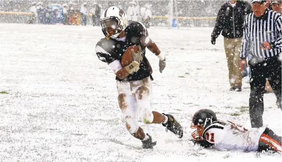  ?? JANE THERESE / SPECIAL TO THE MORNING CALL ?? Catasauqua’s Sa’Quon Burton carries the ball against Northampto­n during a snowy Thanksgivi­ng Day game at Catasauqua in 2010. Northampto­n’s Jeremy Cummings tries to make the tackle. The Rough Riders and Konkrete Kids will meet for the 98th time on Thursday.