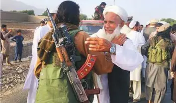  ?? AP ?? Taliban fighters gather with residents in the Surkhroad district of Nangarhar province on Saturday, the same day when a suicide bomber killed 25 people on the outskirts of Jalalabad.