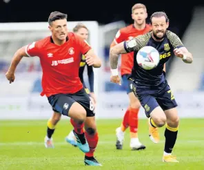  ??  ?? KEY ROLES: Steven Fletcher makes a run in behind the Luton defence, while, right, Danny Batth deals with matters at the back.