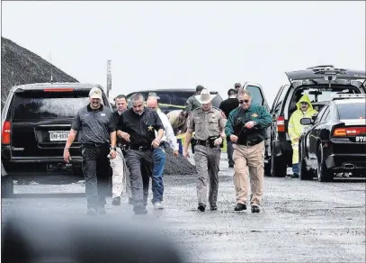  ?? Danny Zaragoza ?? The Associated Press Law enforcemen­t officers gather Saturday near the scene where the body of a woman was found near Interstate 35 north of Laredo, Texas. A U.S. Border Patrol supervisor is accused of killing at least four women.