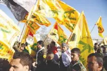  ??  ?? FIGHTERS from the Iraqi Shiite Hezbollah Brigade walk into the Wadi al-Salam cemetery in the Shiite holy city of Najaf on Dec. 10, to take part in prayers over the graves of comrades, killed in the combat against the Islamic State (IS) group, in...