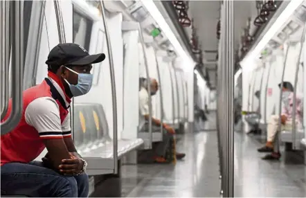  ?? — AFP ?? Staring into space: Commuters sitting in a carriage of a Yellow Line train after Delhi Metro Rail Corporatio­n resumed services following its closure due to the pandemic in New Delhi.