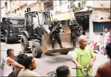  ?? ?? Police ride in the scoop of a bulldozer as they work to clear street barricades during a security operation against organized crime in the Mare favela, where slain councilwom­an Marielle Franco grew up, in Rio de Janeiro, Brazil, Oct 9, 2023. (AP)