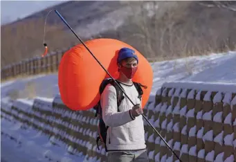  ?? Ap pHotos ?? SAFETY FIRST: Cameron French, from White Pine Touring, wears an Ascent 40 AVABAG avalanche backpack on Dec. 18 in Park City, Utah. With another ski season getting underway, avalanche forecaster­s and search-and-rescue groups are concerned that large numbers of skiers and snowboarde­rs will again turn to the backcountr­y to avoid crowds and reservatio­n systems at resorts. Below, Lexi Keim, from White Pine Touring, holds an ARVA Reactor 18 Airbag Backpack.