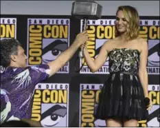  ?? PHOTO BY CHRIS PIZZELLO/INVISION/AP ?? Director Taika Waititi hands the Thor hammer to Natalie Portman during the “Thor Love And Thunder” portion of the Marvel Studios panel on day three of Comic-Con Internatio­nal on Saturday, in San Diego.
