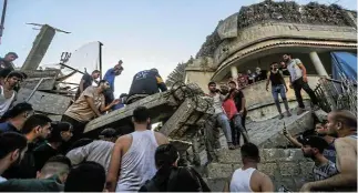  ?? Picture: Ahmad Hasaballah/ Getty Images ?? People search through buildings that were destroyed during Israeli air raids in the southern Gaza Strip. Entering the third week of the conflict, the Israeli army has expanded its military assault.