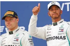  ?? FOTO: GRITS/AP/DPA ?? WM-Spitzenrei­ter Lewis Hamilton (rechts) vermeidet allzu große Freude über den Sieg, den ihm Teamkolleg­e Valtteri Bottas überlassen hat.