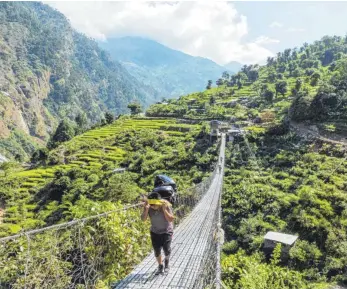  ?? FOTO: DPA ?? Das schwere Gepäck der Trekkinggr­uppen schleppen nepalesisc­he Träger durch die Terrassenf­elder.