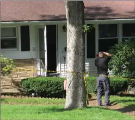  ?? Joseph B. Nadeau photo ?? Investigat­ors comb over the Bluestone Drive property in Woonsocket Sunday, the scene of what was confirmed as a murder-suicide. A 7-year-old boy, the son of both of the deceased, was found safe inside the home, unaware of what had happened.