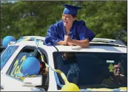  ?? (AP/Daily Herald/Jeff Knox) ?? Katlynn Breneisen, a senior at Warren High School in Gurnee, Ill., celebrates Sunday during a parade through the parking lot at the school’s graduation ceremonies. Such parades have been seen at many schools as graduates mark the occasion while practicing social distancing.