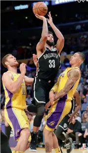  ?? AP ?? Allen Crabbe of Brooklyn Nets (centre) goes to the basket in between Los Angeles Lakers’ Brook Lopez (left) and Kyle Kuzma during their NBA game on Friday. —