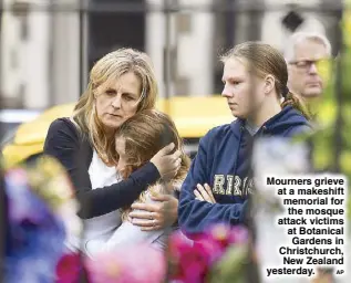  ?? AP ?? Mourners grieve at a makeshift memorial for the mosque attack victims at Botanical Gardens in Christchur­ch, New Zealand yesterday.