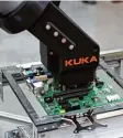  ??  ?? Der Kuka Roboterarm greift auf das Mainboard von Fujitsu zu.