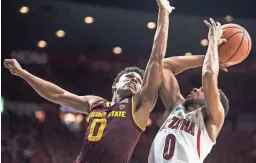  ?? SEAN LOGAN/THE REPUBLIC ?? ASU’s Tra Holder tries to block UA’s Parker Jackson-Cartwright’s shot during Saturday’s game in Tucson.