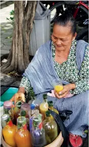  ??  ?? AN ELDERLY MBOK JAMU GENDONG, JAMU-SELLER WOMAN