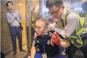  ?? ELSON LI/HK01 ?? District councilor Andrew Chiu receives medical treatment in Hong Kong Sunday after a knife-wielding man attacked several pro-democracy protesters.