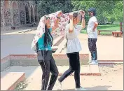  ?? ?? Girls cover their head to protect themselves from scorching heat, at Humayun's Tomb, in New Delhi.