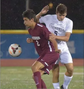  ?? PETE BANNAN — DIGITAL FIRST MEDIA ?? West Chester Henderson’s Nick Dinacci keeps the ball from Unionville’s Evan Dougherty (5) Monday evening as the Warriors defeated Unionville 1-0 on a goal by Kevin Kiefer.