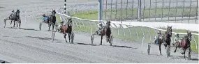  ?? CLIFFORD SKARSTEDT EXAMINER ?? Horses and their drivers approach the finish line in a qualifier from the empty seating area on the opening night of 2020 racing season at Kawartha Downs on Saturday night.