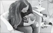  ?? Denise Hurdle Photograph­y ?? BRIANA WALKER holds her son in the neonatal intensive care unit at UC Irvine Medical Center on Feb. 28. He tested positive for MRSA on March 6.