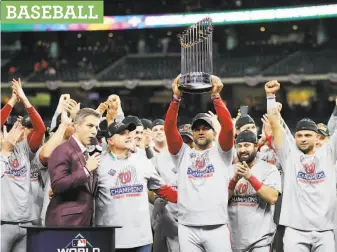  ?? Elsa / Getty Images ?? Washington manager Dave Martinez hoists the World Series trophy Wednesday night, a possibilit­y that seemed farfetched after the Nationals started the season 1931.