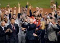  ??  ?? Below: Jim
Crane hoists the Commission­er’s Trophy after his Houston Astros win the 2017 World Series; Washington Capitals’ owner Ted Leonsis hoists the Stanley Cup in 2018.