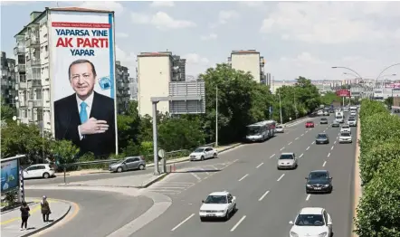  ?? — AFP ?? Vote for me: A campaign banner for Erdogan with the slogan which translates as ‘AKP can do it again’ hanging from a block of apartments in Ankara.